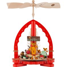 a red clock tower with various toys on it's sides and a white ceiling fan hanging from the top