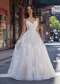 a woman in a wedding dress standing on the street