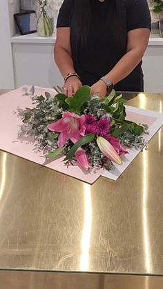 a woman standing in front of a table with flowers on it