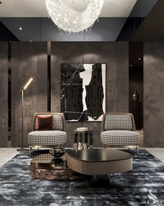 a living room with two chairs and a coffee table in front of a chandelier