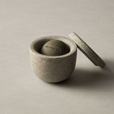 a stone mortar bowl with a small rock in the middle and a stick sticking out of it