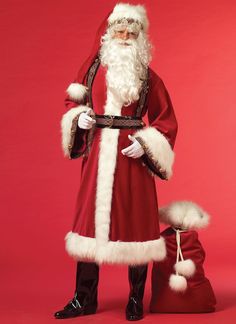 a man dressed as santa claus standing in front of a red background