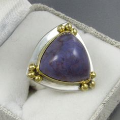 "A gorgeous rich lavender color with swirling patterns in reddish purple, I've set this incredible high-domed gem quality Lavender Jade cabochon (which I cut) in an 18kt gold bezel with accent orbs of 18kt gold upon a sterling silver base. The richness of the 18kt Gold and the color of the Lavender Jade make this a real attention stealing \"Statement\" ring. The character and color of this Lavender Jade from Turkey have made it one of my favorites with which to work and always draws great attent Formal Purple Cabochon Ring, Luxury Purple Ring As Gift, Luxury Purple Ring As A Gift, Luxury Purple Ring For Gift, Luxury Purple Rings For Gift, Fine Jewelry Purple Amethyst Cabochon Ring, Purple Amethyst Cabochon Ring Fine Jewelry, Fine Jewelry Purple Cabochon, Luxury Collectible Purple Rings