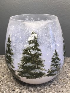 a glass with snow and trees painted on it