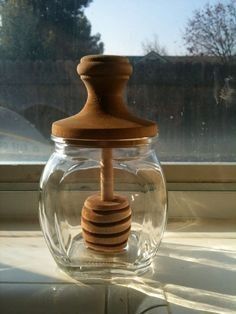 a glass jar with a wooden stopper in it sitting on a window sill