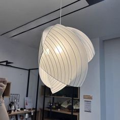 a large white light hanging from the ceiling in a room with shelves and other items