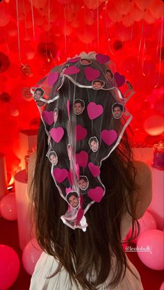 the back of a woman's head with pink and red balloons in the background