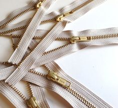 several gold zippers are lined up on a white surface