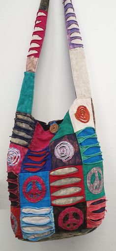 a handbag made out of different colored fabrics and buttons on the front with peace signs