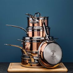 a stack of pots and pans sitting on top of a wooden board