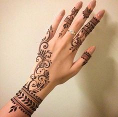 a woman's hand with henna tattoos on it