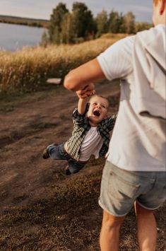 a man holding a small child up in the air