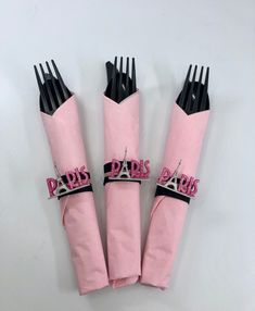 four pink napkins with black forks in the shape of paris and eiffel tower