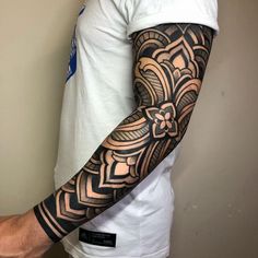 a man's arm with an intricate tattoo design on the arm and shoulder,