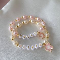 Flower Girl Bracelets personalized with her monogram initial make a pretty gift for any little girl in your bridal party.  The bracelet is made with faux pearls and alternating 18K gold-plated beads. Name Charm Bracelet, Beaded Bracelets Name, Flower Girl Bracelet, Personalized Pink Charm Bracelet For Birthday, Customizable Pink Charm Bracelet For Birthday, Customized Pink Name Bracelet Adjustable, Customized Pink Name Bracelet With Adjustable Fit, Customized Pink Adjustable Name Bracelet, Cute Pink Name Bracelet