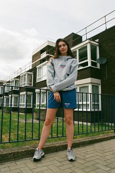 a woman standing on a sidewalk in front of a building Spring Athleisure Sweatshirt With Embroidered Logo, Sporty Hoodie With Embroidered Logo For Spring, Casual Sports Sweatshirt With Embroidered Logo, Sporty Hoodie With Embroidered Logo For Loungewear, Sporty Relaxed Fit Hoodie For Spring, Sporty Relaxed Fit Spring Hoodie, Sporty Spring Hoodie With Relaxed Fit, Spring Sporty Hoodie In Relaxed Fit, Spring Sporty Hoodie With Relaxed Fit