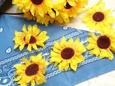 yellow sunflowers are placed on a blue bandana and some other flowers sit next to it