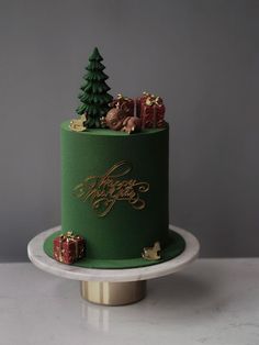 a green christmas cake with trees and presents on top