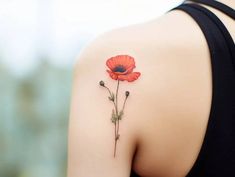 a red flower on the back of a woman's shoulder, with two stems attached to it