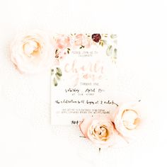 the wedding stationery is laid out on top of the table with pink flowers and greenery