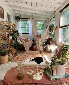 a living room filled with lots of furniture and plants