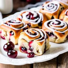 a white plate topped with rolls and cherries