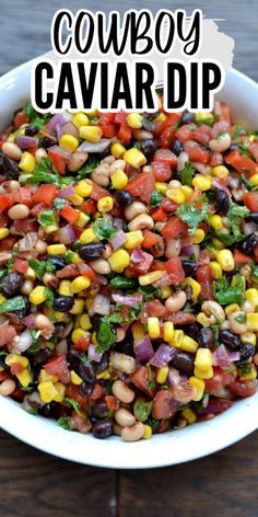 a white bowl filled with black eyed peas, corn and cilantro sauce on top of a wooden table