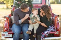 a family sitting in the back of a pickup truck