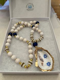 "Hanukkah decor, Hanukkah necklace, Star of David Prayer Beads, Oyster Shell Necklace, Jewish Art, Jewish Prayer Beads, Hanukkah Gifts, Blessing Beads These Beautiful oyster shell blessing beads will add that coastal vibe to your table, displayed on a mantel, displayed during the holiday season. Glossy Oyster Shell Garland, House warm Gift, Hostess Gift, Passover Gift, Hanukkah Gift, Oyster Shell Garland, Nautical Themed ❤️ALL OUR SHELL DESIGNS ARE UV RESIN - THEY ARE WATER RESISTANT - NOT WATER Spiritual Gemstone Beaded Necklaces For Celebration, Unique Beaded Necklaces With 8mm Beads As Gift, Oyster Shell Garland, Shell Garland, Jewish Prayer, Jewish Necklace, Blessing Beads, Murrells Inlet Sc, Hanukkah Decor