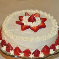 a cake with white frosting and strawberries on top