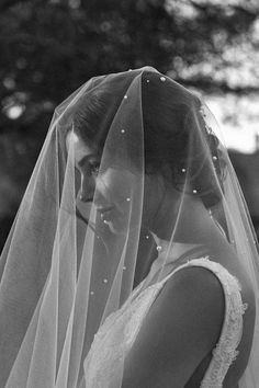 black and white photograph of a woman in her wedding dress wearing a veil with pearls on it