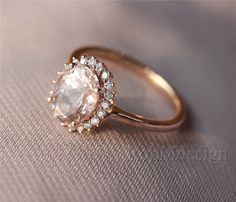 an engagement ring with a large white stone surrounded by small diamonds on a beige cloth