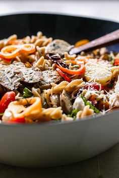 a bowl filled with pasta and vegetables on top of a table