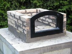 a brick oven sitting on top of a cement block