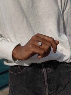 a close up of a person wearing a ring with a diamond on it's finger