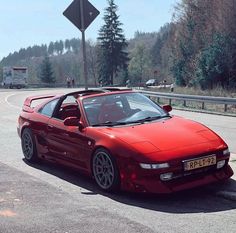 a red sports car is parked on the side of the road