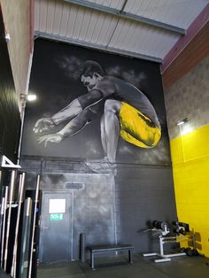 a mural on the side of a building with a man holding a yellow frisbee