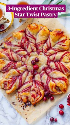 cranberry swirl pastry sitting on top of a cutting board next to two cups of tea