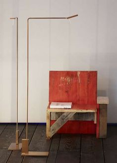 a wooden bench sitting on top of a hard wood floor next to a light pole