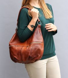 "LEATHER SHOULDER BAG is made of 100% high quality leather. Very practical for carrying on the shoulder, and cross body. The purse closes with a zipper. Two pockets with zip at the front. Inside there is one zippered pocket and one on the phone. Additional zip pocket at the back of the bag. To be worn on the shoulder or in the hand. Has a long adjustable strap. Interior finished with lining. >> To see the FULL DESCRIPTION of the purse, click the \"+ MORE\" button below DIMENSIONS: Height: Leather Satchel Hobo Bag With Smooth Grain, Leather Hobo Bag With Smooth Grain Satchel, Leather Hobo Bag With Smooth Grain, Cognac Hobo Bag With Smooth Grain For Everyday, Everyday Saddle Bags With Leather Handles, Luxury Leather Saddle Bag For Errands, Everyday Saddle Shoulder Bag With Removable Pouch, Soft Leather Saddle Bag For Travel, Leather Lined Hobo Travel Bag