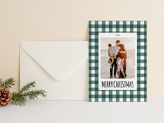 a christmas card with an image of two people on it and a pine cone next to it