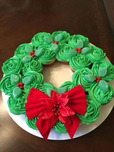 green frosted cupcakes in the shape of a wreath on top of a white plate