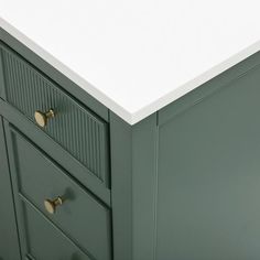 a white counter top sitting next to a green cabinet