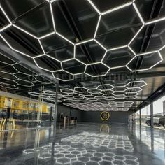 the inside of an empty building with lots of windows and lights hanging from the ceiling