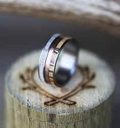 two wedding rings sitting on top of a piece of wood