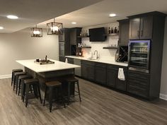 a kitchen with an island and bar stools next to it in the center of the room