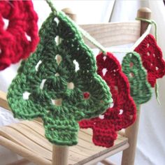 crocheted christmas tree decorations hanging from a wooden chair