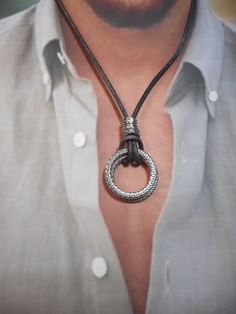 "Men need bling too!   Two silver rings suspended from a quality leather cord. Adorned with further silver accents. I have three options: 1. Premium black 2mm leather cord comes in either adjustable WITH TWO SLIDING KNOTS (up to 26\" long) or choose your custom length which will come with an ornate silver clasp as pictured.  The non-adjustable necklace will have an ornate silver hook & eye closure as pictured.   2. SHOWN:  Premium dark antique brown 2mm leather cord comes in either adjustable WI Silver Leather Jewelry, Round Leather Silver Jewelry, Male Necklace Leather, Silver Leather Necklace With Adjustable Cord, Viking Oxidized Pendant Necklace, Viking Style Stainless Steel Pendant Necklace, Leather Cord Jewelry, Viking Style Nickel-free Pendant Necklace, Viking Pendant Necklace Collectible