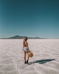 a woman standing in the middle of a desert