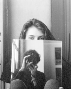 a woman holding up a photo in front of her face